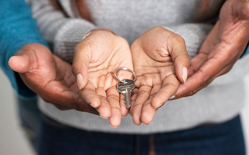 woman and man holding house keys in open hands