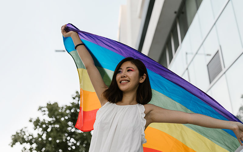 Young Asian woman holding rainbow flag